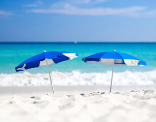 Two blue and white beach umbrellas on a white sandy beach .It is well suited for advertising, editorial or web and magazine covers, especially in the travel, leisure or summer sectors.