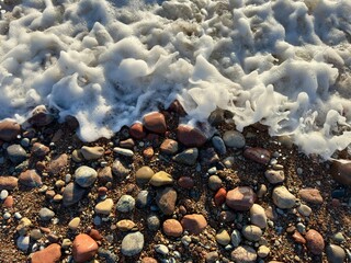 stones on the beach with foam