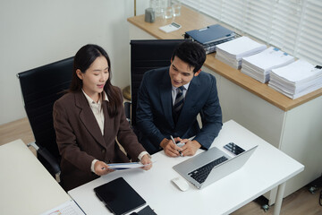 Asian business team working on a project in the office or reviewing and discussing a business project.