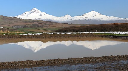 Snow-capped mountain range mirrored on still waters creates a breathtaking scenery