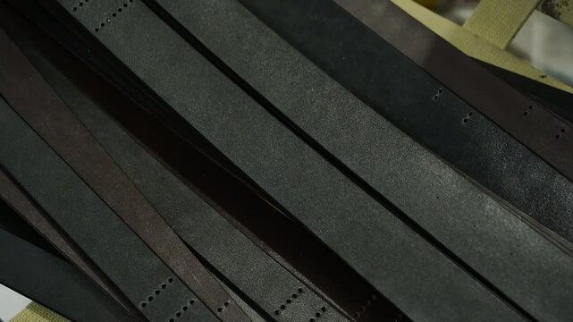 Side tracking shot of leather belts arranged in one direction