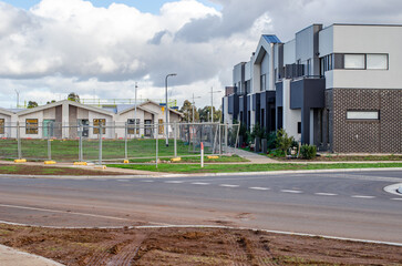 New housing estate in an outer suburb featuring freshly built modern townhouses. Temporary fencing...