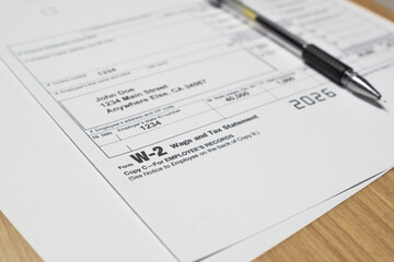 Tax document for the IRS W-2 Tax form on wooden table in office or at home