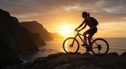 Obraz premium Silhouette of a cyclist at sunset overlooking the ocean