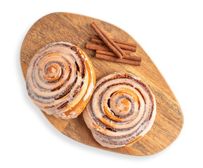Top view of two delicious homemade sweet cinnamon rolls bun or swirl with spice sticks on wooden...