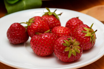 Freshly harvested strawberries on a white plate ready for dessert