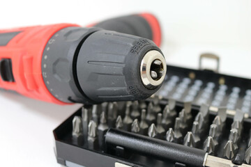 Electric drill with open bit case and metal bits