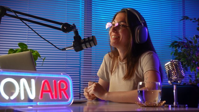Female Podcaster Engaged in Lively Broadcast with Stylish Setup