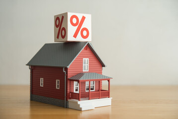 House model and interest rate box (percentage sign). Mortgage loan, burden payment from high interest rate, FED central bank control monetary policy, financial risk management, home finance concept.