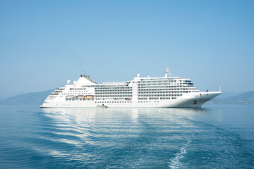 Luxury cruise ship sailing in calm sea on a clear sunny day with blue sky