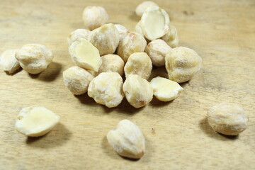 Raw candlenuts on a wooden background. Perfect for food photography, culinary ingredients, and traditional cooking concepts