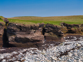 Layers of peat layered atop a rocky beach at Heoga Ness, Shetland, show the rugged coastal charm.
