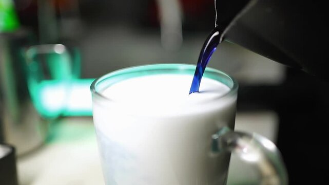 Slow Motion Butterfly Pea Syrup Pouring into Frothed Milk with Herbal Topping
