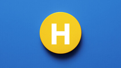 Obraz premium Round wooden disk painted bright yellow with bold letter H centered perfect for alphabet icon signage monogram education learning initial or creative typography lettermark design visuals