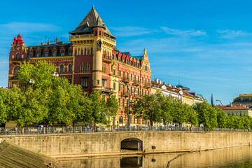 A view along the east bank of the Vltava river past ornate buildings in Prague in springtime