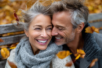 Happy couple enjoying autumn together in a park surrounded by falling leaves