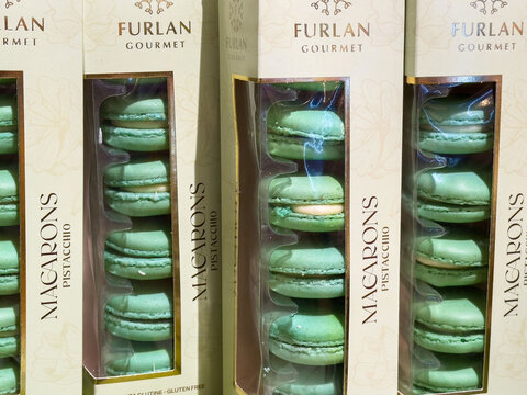 Venice, Italy - June 23, 2025: Green pistachio macarons in elegant packaging from Furlan Gourmet, showcasing gourmet dessert artistry and delightful confectionery presentation