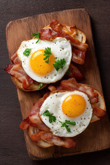 delicious crispy bacon and fried eggs on toasted bread, top view
