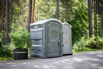 Portable Toilets in Forest Park Setting for Outdoor Events or Public Convenience Infrastructure