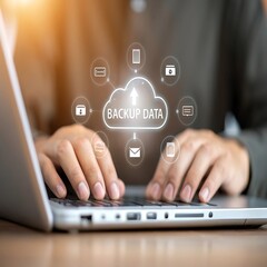 Person typing on laptop with cloud backup data graphic hands