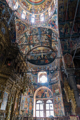 Domed Ceiling Frescoes and Ornate Wall Murals in Rila Monastery Church, Illuminated by Natural Light