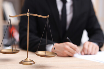 Judge working and scales on desk indoors, selective focus