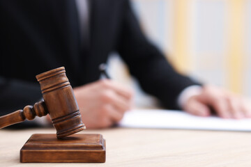 Judge working and gavel on desk indoors, selective focus