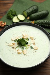Tasty cucumber soup with croutons and broccoli on wooden table, closeup