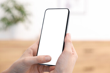 Woman using modern smartphone at home, closeup