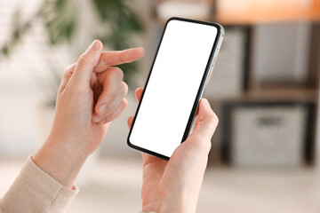 Woman using modern smartphone at home, closeup