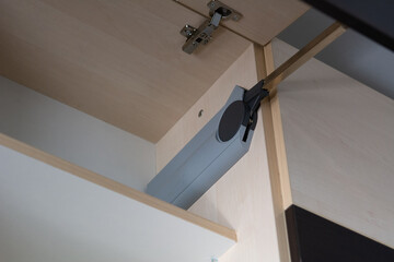 Lifting mechanism of the kitchen cabinet. Kitchen cabinet with a soft-closing system. Selective focus, shallow depth of field