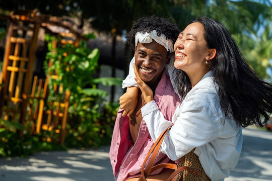 Interracial couple enjoying a romantic beach getaway, embracing love, laughter, and togetherness - Powered by Adobe