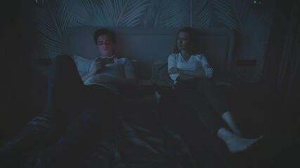 Silhouette couple in bed family problem. Sad upset lonely woman wife offended get mad at man husband addict with mobile phone social media addicted game web apps, guy ignoring girl without attention - Powered by Adobe