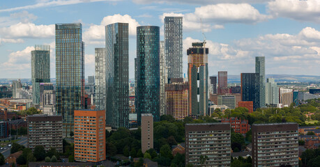 Obraz premium Panoramic aerial image of the modern newly constructed skyline of Manchester UK with white clouds above 