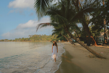 Asian woman relaxing walking on beach during her travel vacation in Thailand