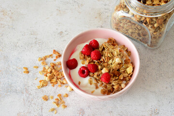 Healthy breakfast bowl with granola, yogurt and raspberries flat lay copy space