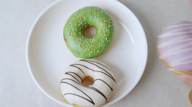 Serving colorful icing glazed Donuts on a white background.