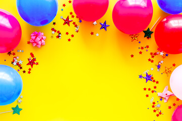 Decorative frame with colorful balloons on yellow background top-down frame copy space