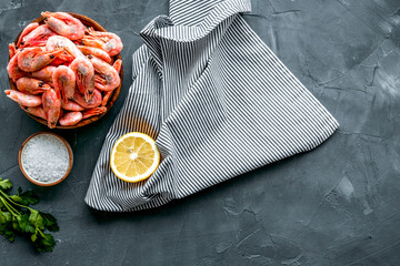 Shrimps for mediterranean salad - with lemon and greeenery - on grey desk top view copy space