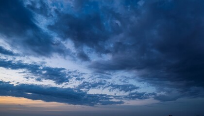 timelapse shot of cloudy sky flowing billowing moving horizontally from left to right blue clouds during sunset in dark color tone