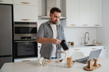 Man Brewing Fresh Coffee with French Press in Modern Kitchen