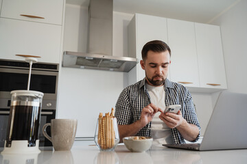  Man Working from Home with Coffee and Snacks in Modern Kitchen