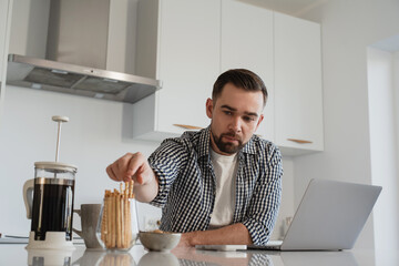  Man Working from Home with Coffee and Snacks in Modern Kitchen