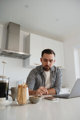  Man Working from Home with Coffee and Snacks in Modern Kitchen