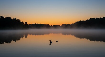 Obraz premium Serene lake at sunrise with tranquil water and fog