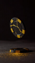 Two Black and Gold Casino Chips with Glitter on Dark Surface