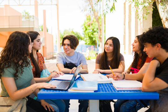 Group of friends and high school students collaborating on a project outdoors