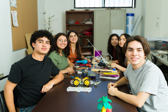 Group of Latin students collaborating on robotics project in high school - Powered by Adobe