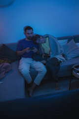 Couple Playing Video Games Together in Cozy Living Room at Night