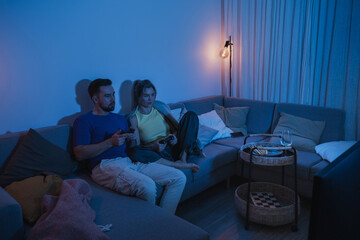 Couple Playing Video Games Together in Cozy Living Room at Night